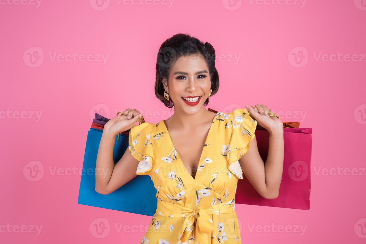 schöne asiatische Frau, die farbige Einkaufstaschen hält foto