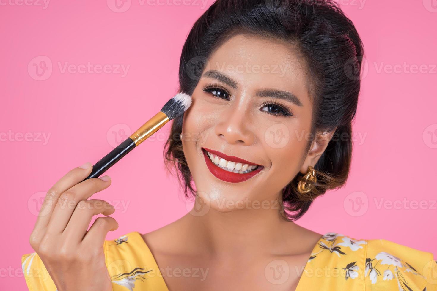 Porträt einer Frau mit Make-up Pinsel foto