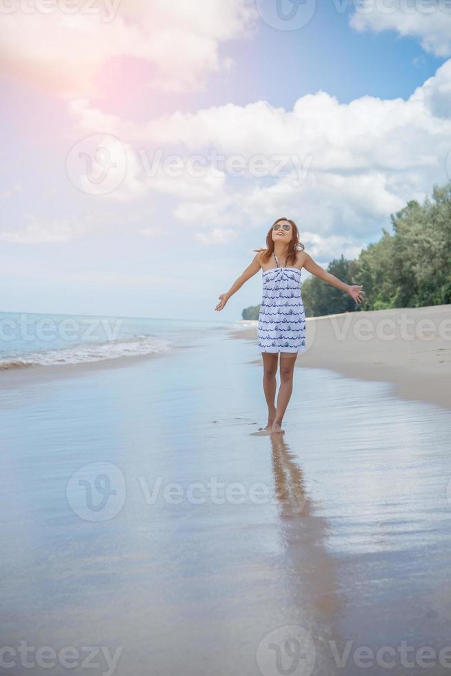 junge schöne glückliche Frau, die den Strand genießt foto