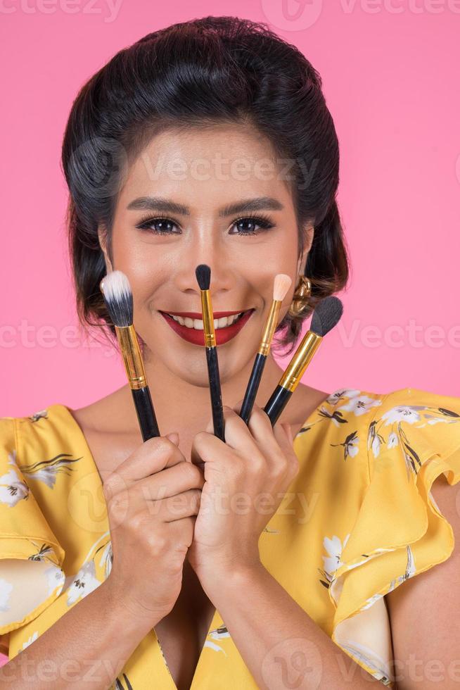 Porträt einer Frau mit Make-up-Pinseln foto