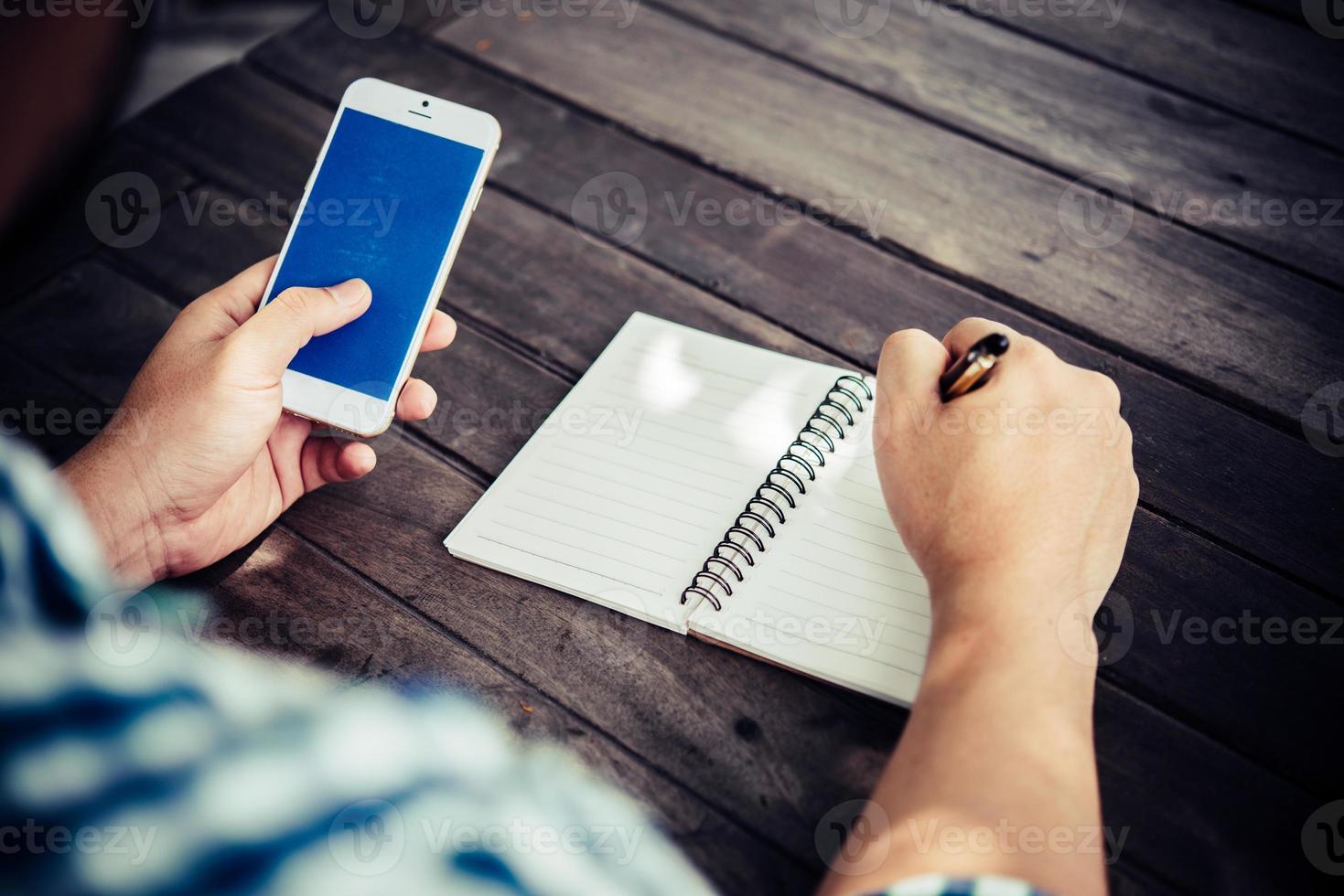 Nahaufnahme des Geschäftsmannes mit Smartphone während der Arbeit im Café foto