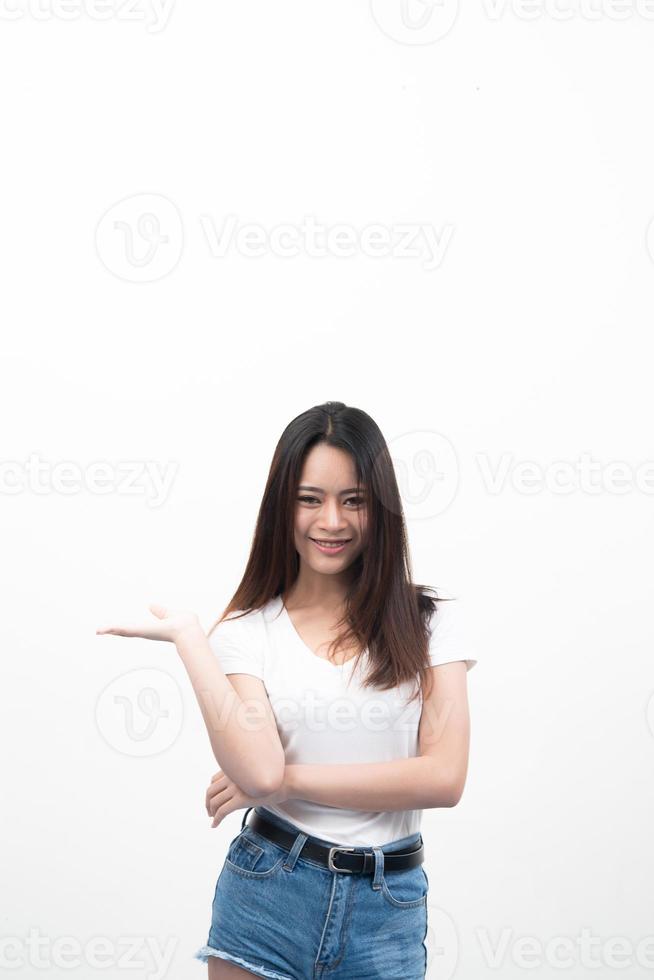 schöne junge asiatische Frau mit Hand, die für Werbung lokalisiert auf weißem Hintergrund zeigt foto