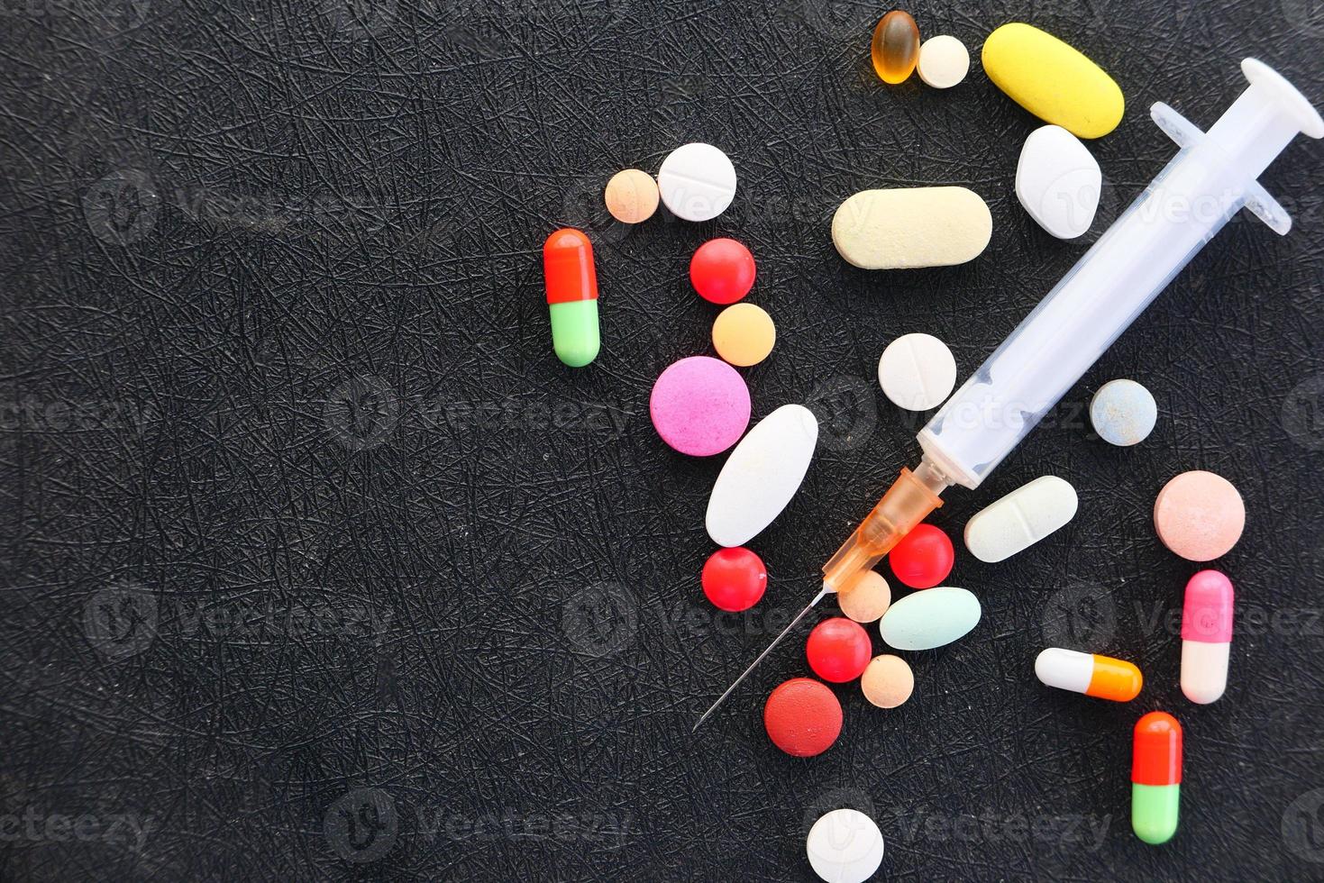 Spritze und Pillen auf einem dunklen Hintergrund foto