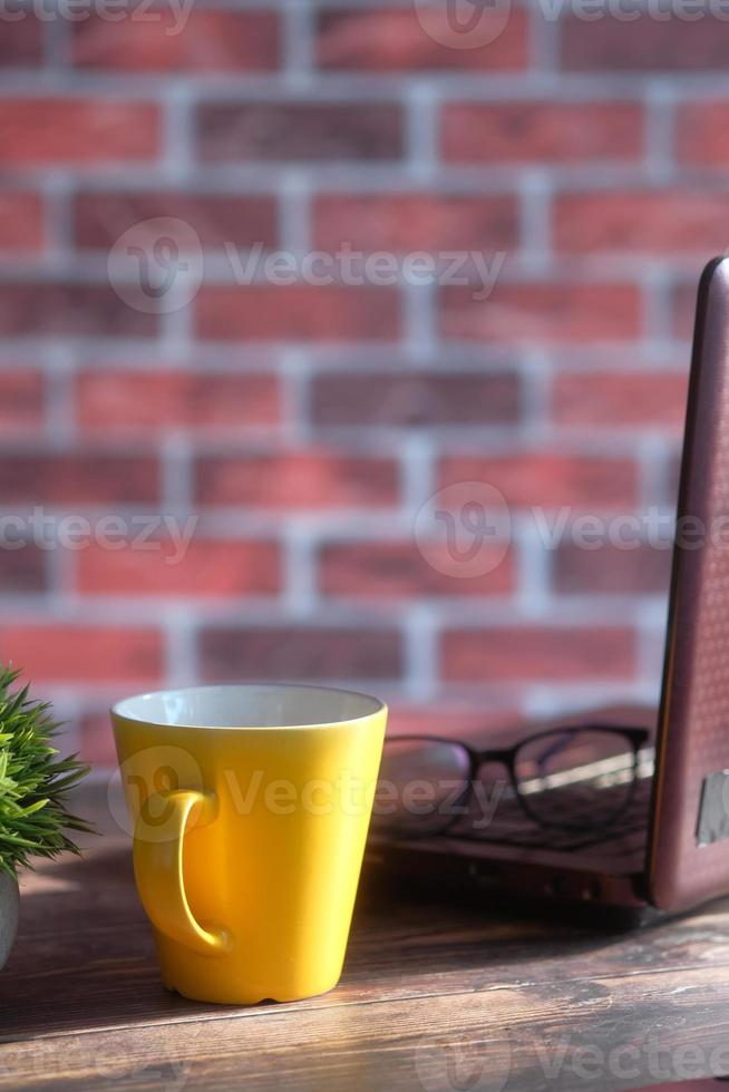 gelbe Tasse auf einem Desktop foto