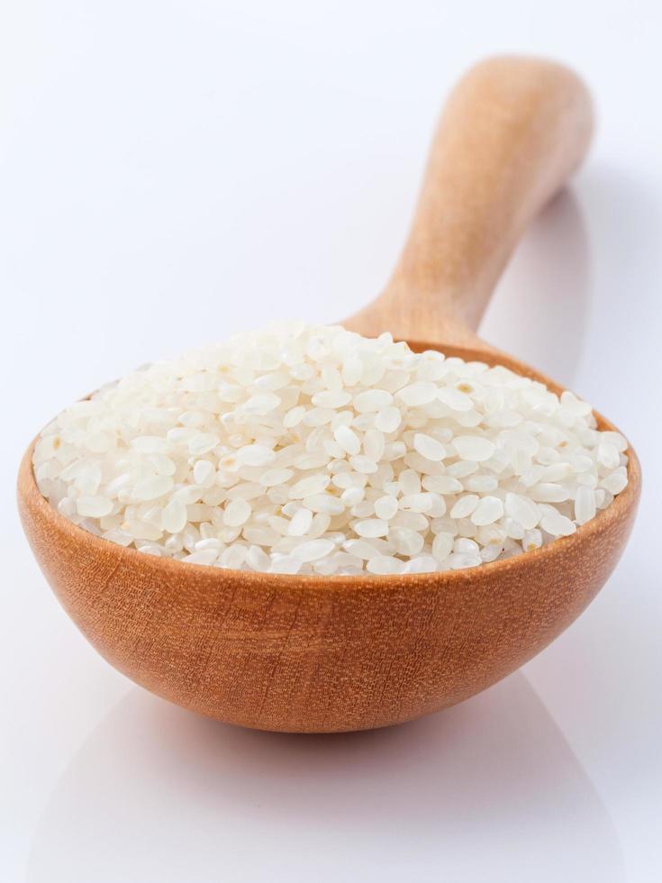 Reis in einem Löffel auf einem weißen Hintergrund foto