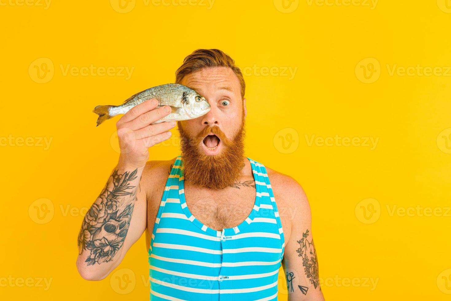 Mann mit Bart und Badeanzug gefangen ein Fisch foto