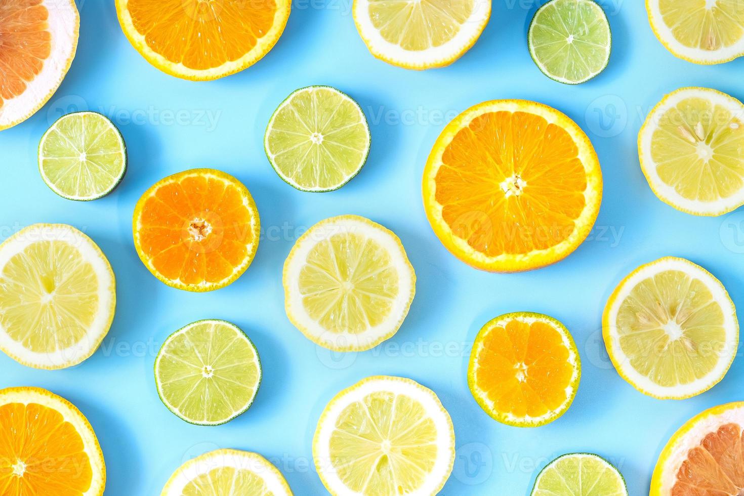 Sammlung von frischen Limetten-, Zitronen-, Orangen-, Zitrus-, Grapefruitscheiben auf blauem Hintergrund. foto