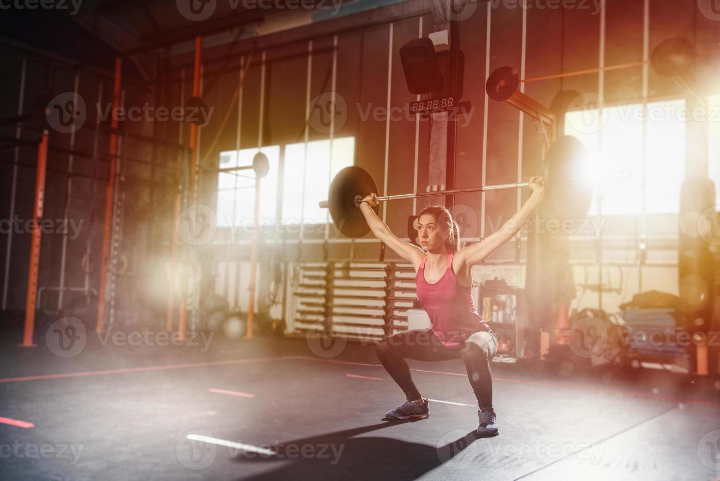 sportlich Mädchen funktioniert aus beim das Fitnessstudio mit ein Hantel foto