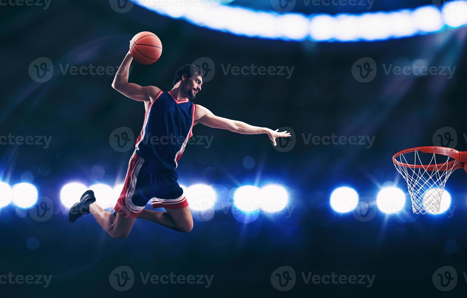 akrobatisch zuschlagen Dunk von ein Korb Spieler im das Korb beim das Stadion foto