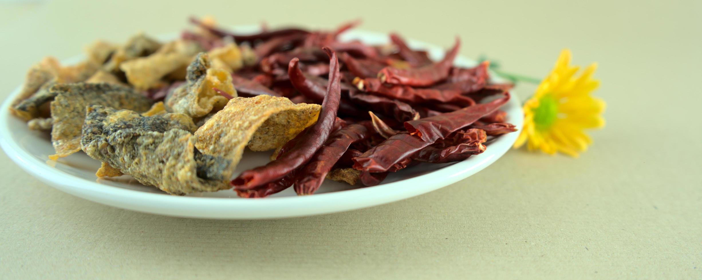 knusprig gesalzene Fischschalen mit getrockneten glühenden Chilis foto