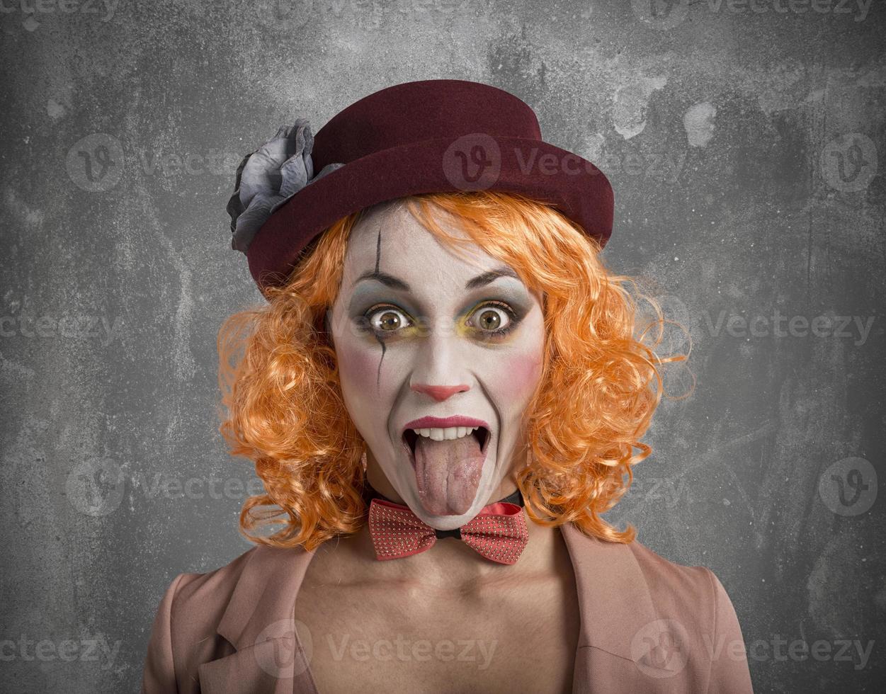 komisch Grimasse Clown Mädchen Mädchen mit Zunge draußen foto