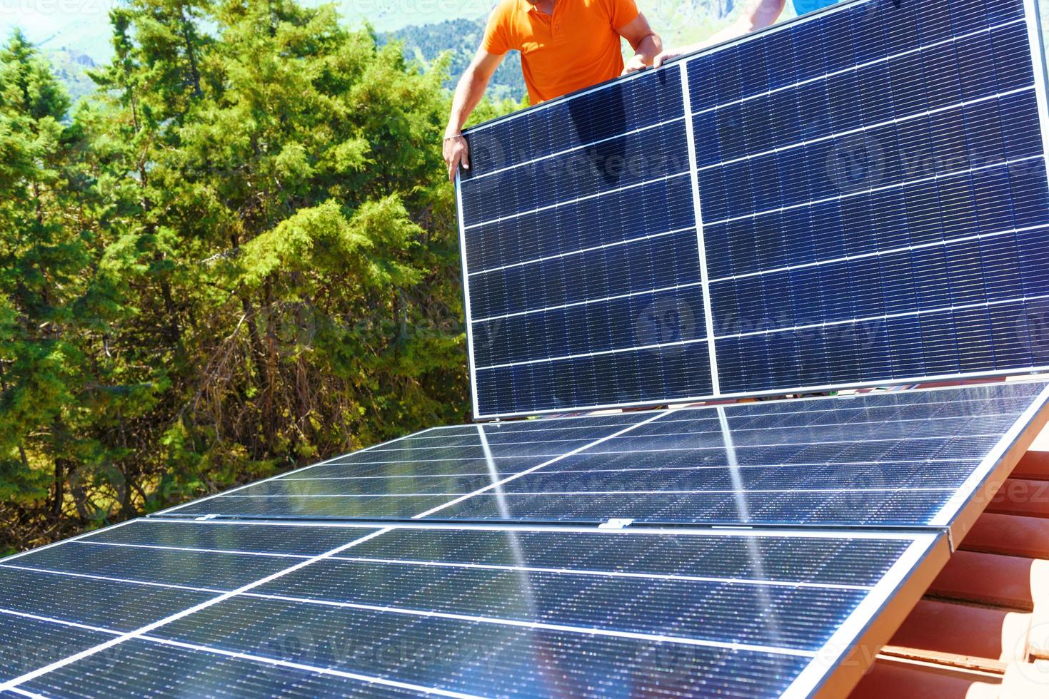 Arbeitskräfte montieren Energie System mit Solar- Panel zum Elektrizität und heiß Wasser foto