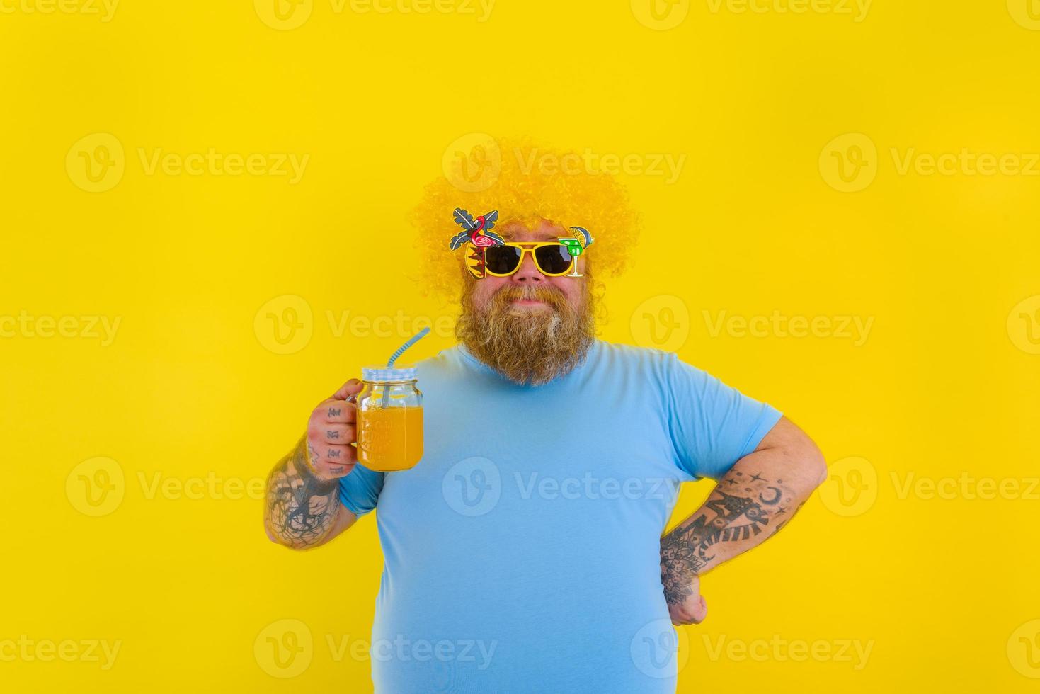 Fett glücklich Mann mit Perücke im Kopf und Sonnenbrille Getränke ein Obst Saft foto