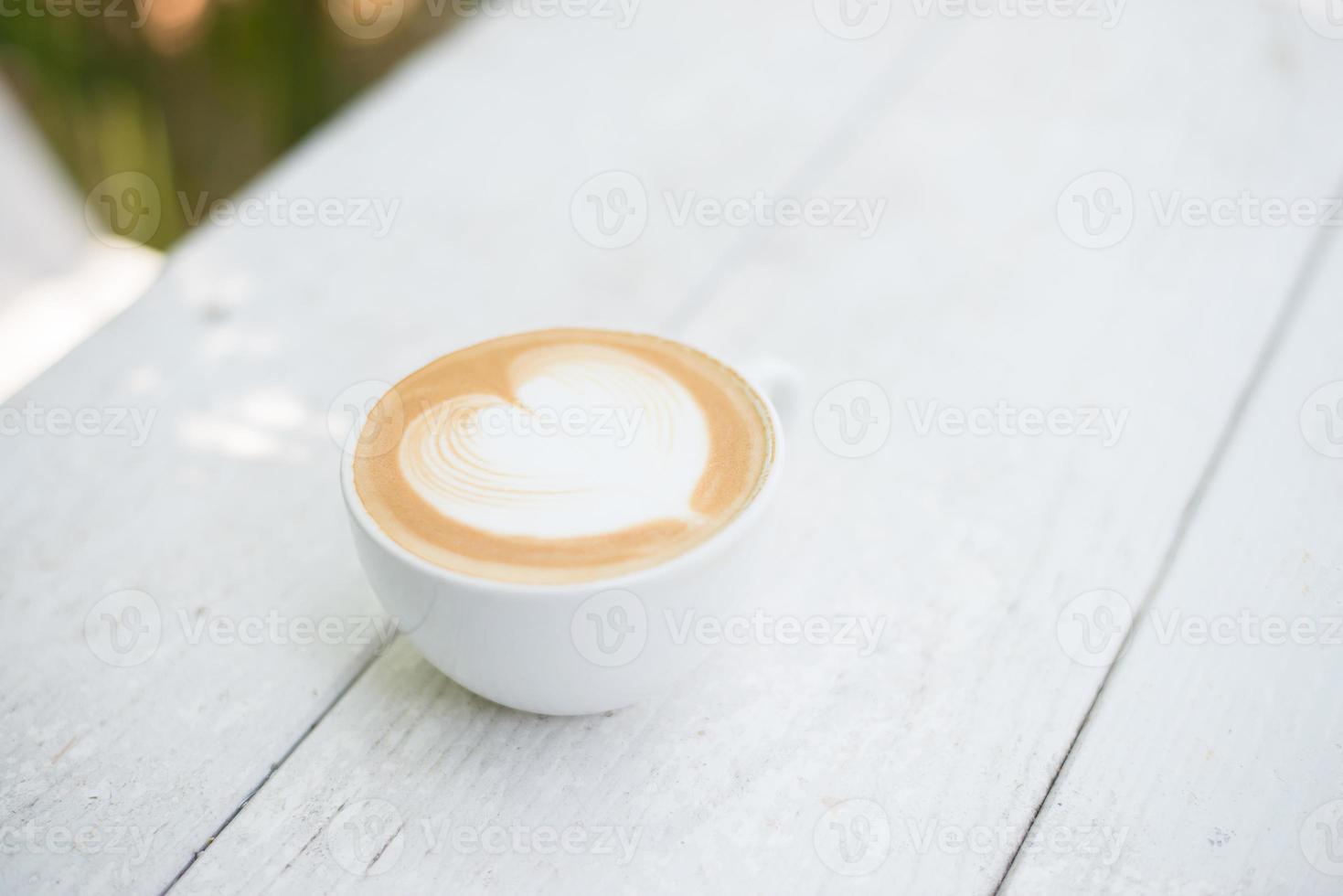 Tasse Latte Art Herzform Kaffee auf weißem Tisch foto