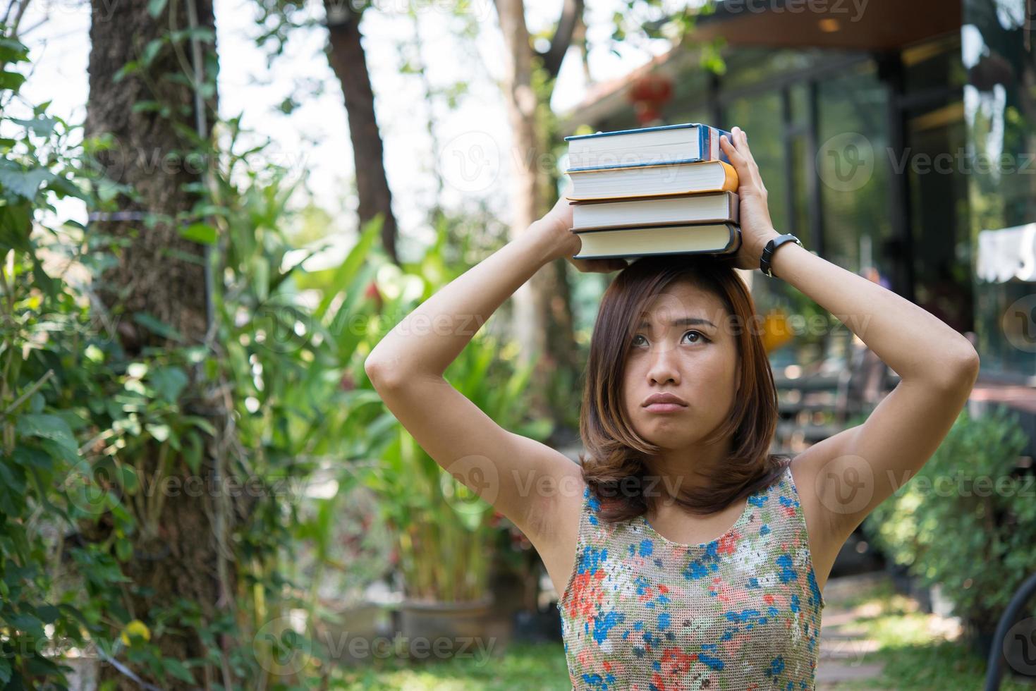 glückliche junge Frau stehend und hält Notizbücher im Hausgarten foto