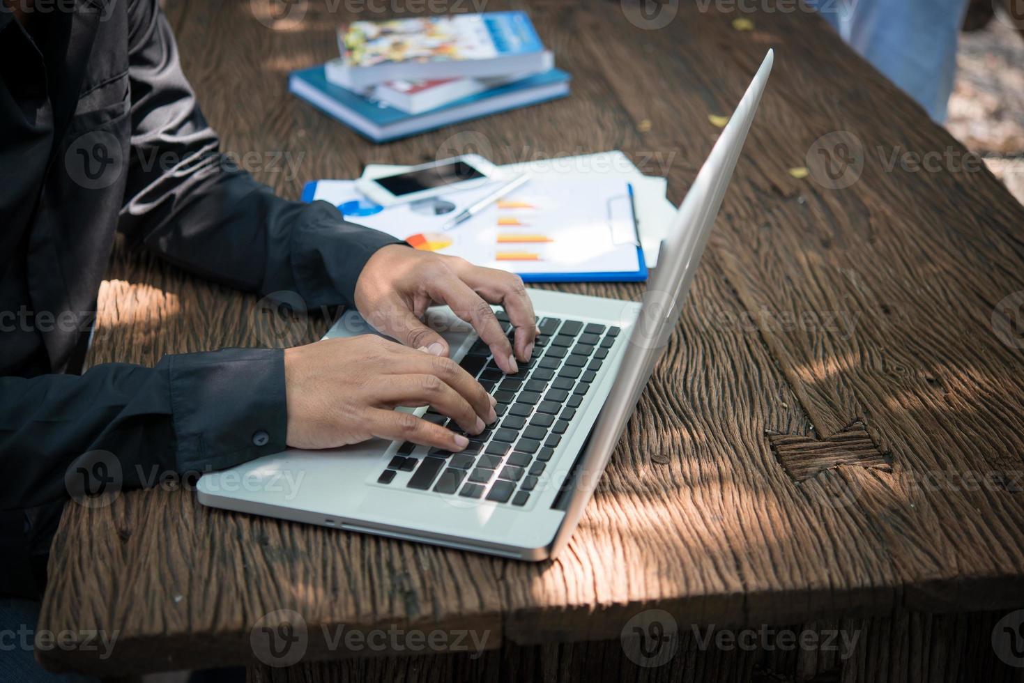 Geschäftsfrau, die mit neuem Startprojekt arbeitet und auf Laptop am Holztisch tippt foto