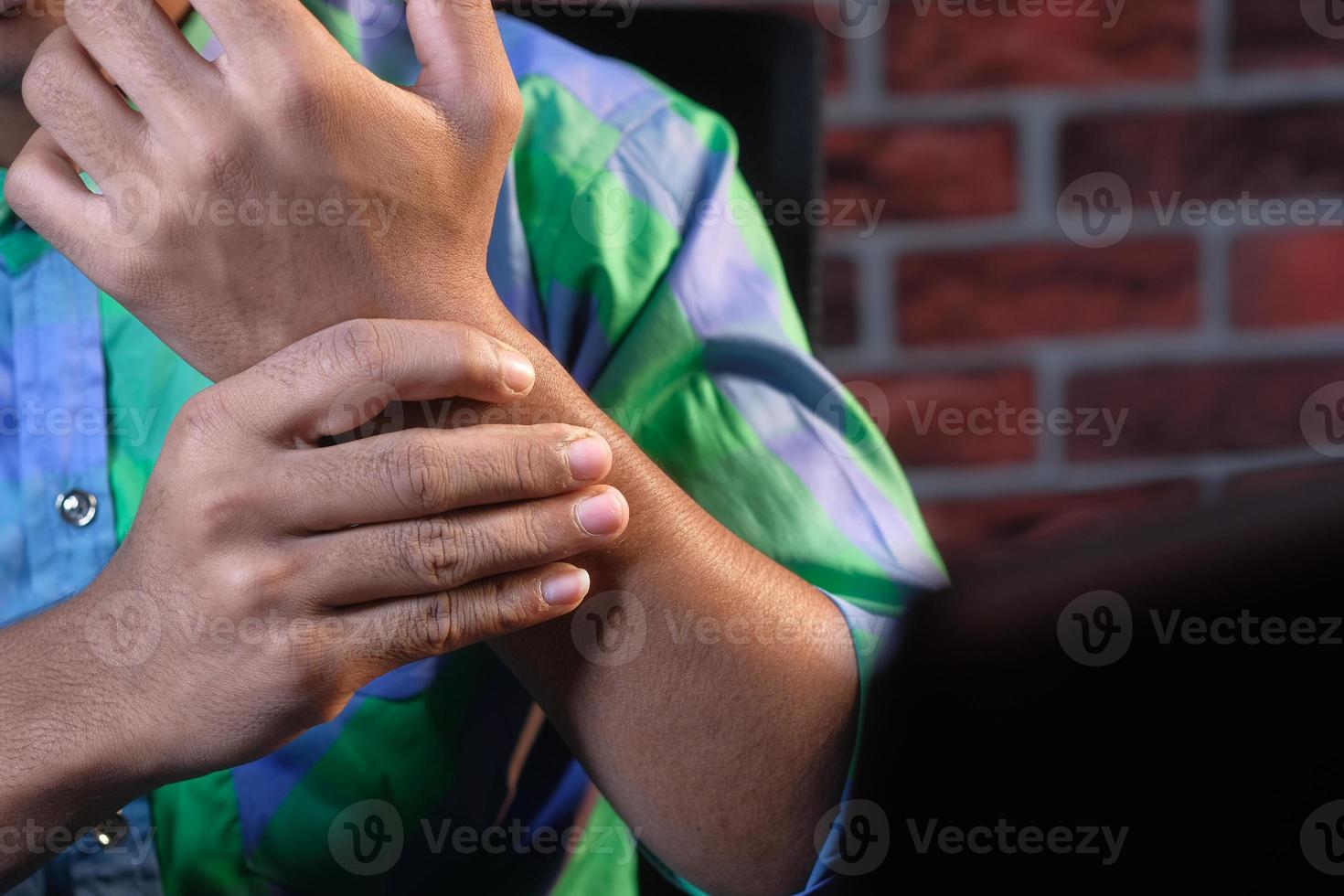 junger Mann mit Schmerzen am Handgelenk foto