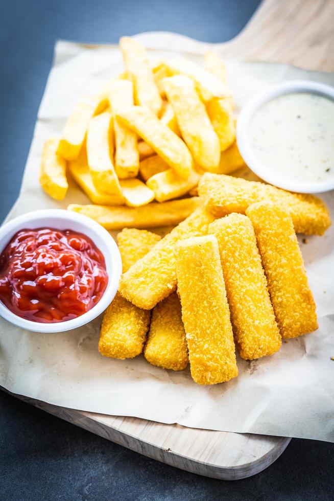 Fischstäbchen und Pommes Frites mit Ketchup und Mayonnaise-Sauce foto