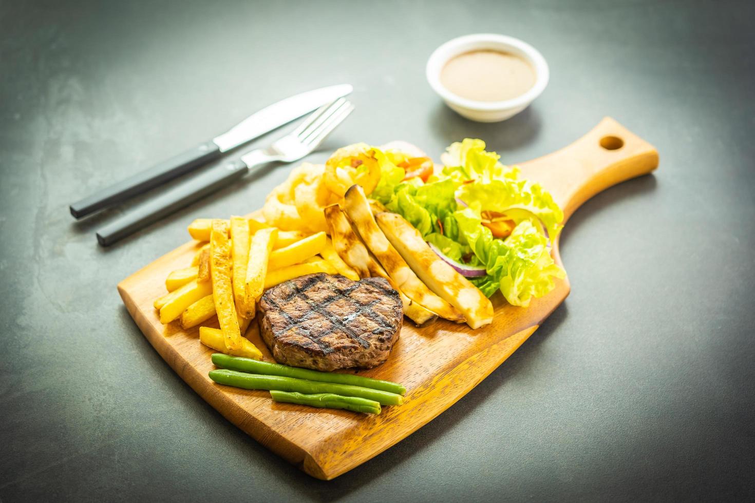 Gegrilltes Rindersteak mit Pommes Frites, Sauce und frischem Gemüse foto