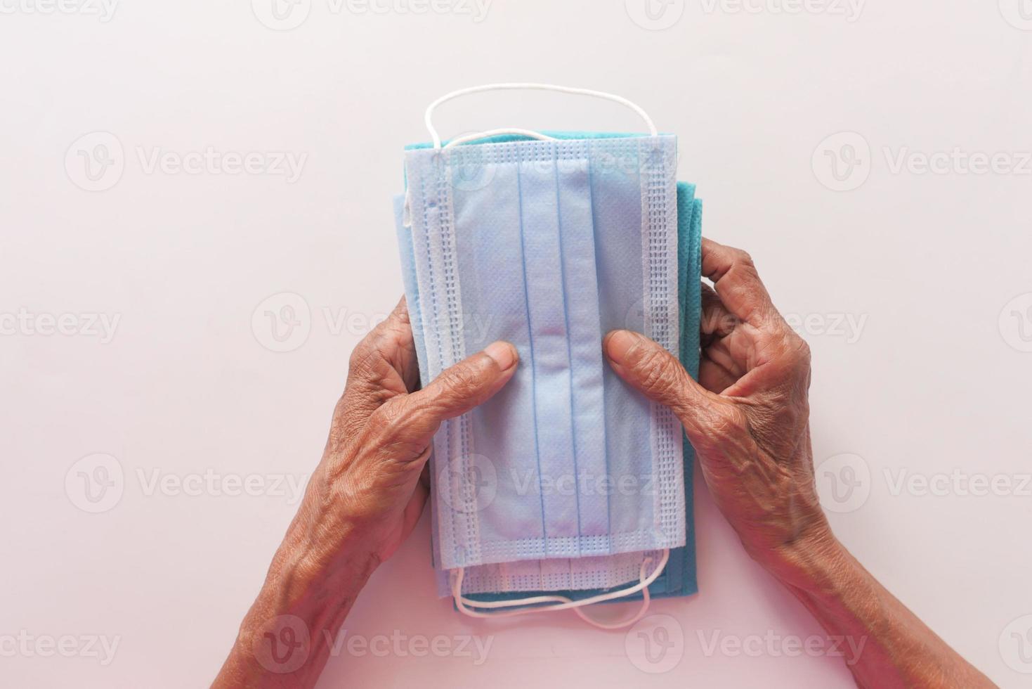 Hand der älteren Frau, die Gesichtsmasken hält foto
