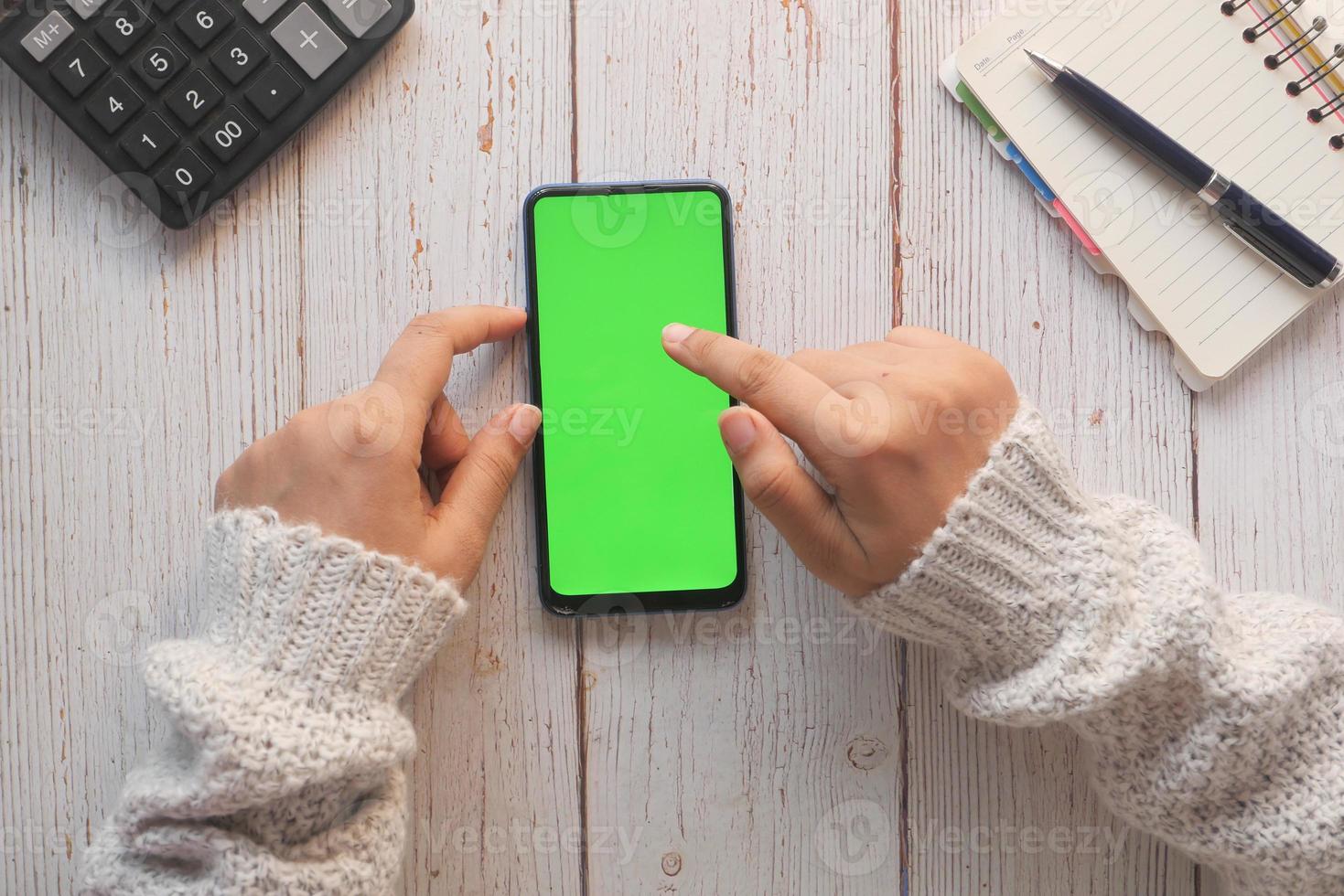 Draufsicht der Frau, die Handy mit grünem Bildschirm verwendet foto