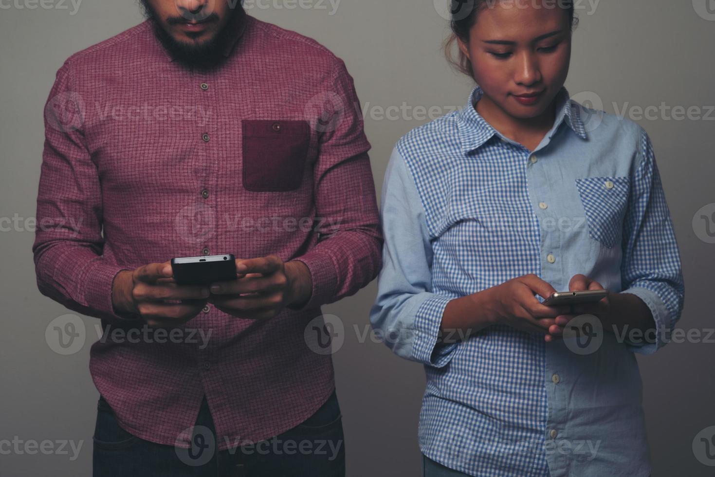 glückliches Paar, das Textnachrichten auf schwarzem Hintergrund sendet foto