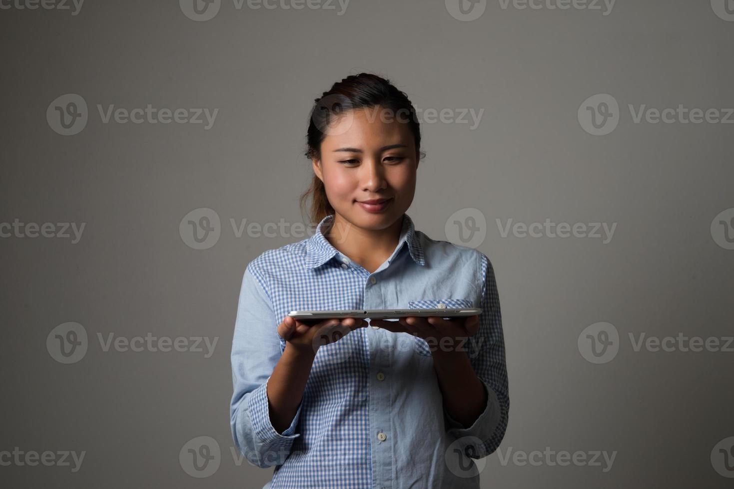 Frau, die auf digitalem Tablett lokalisiert auf schwarzem Hintergrund hält foto