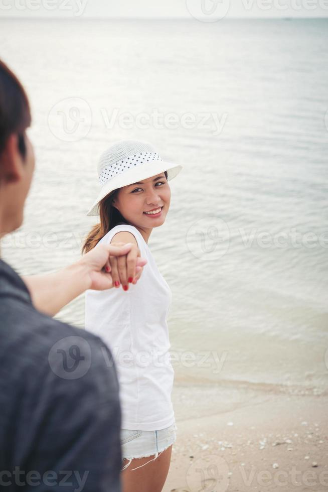 Freundin bringt ihren Freund zum Strand foto