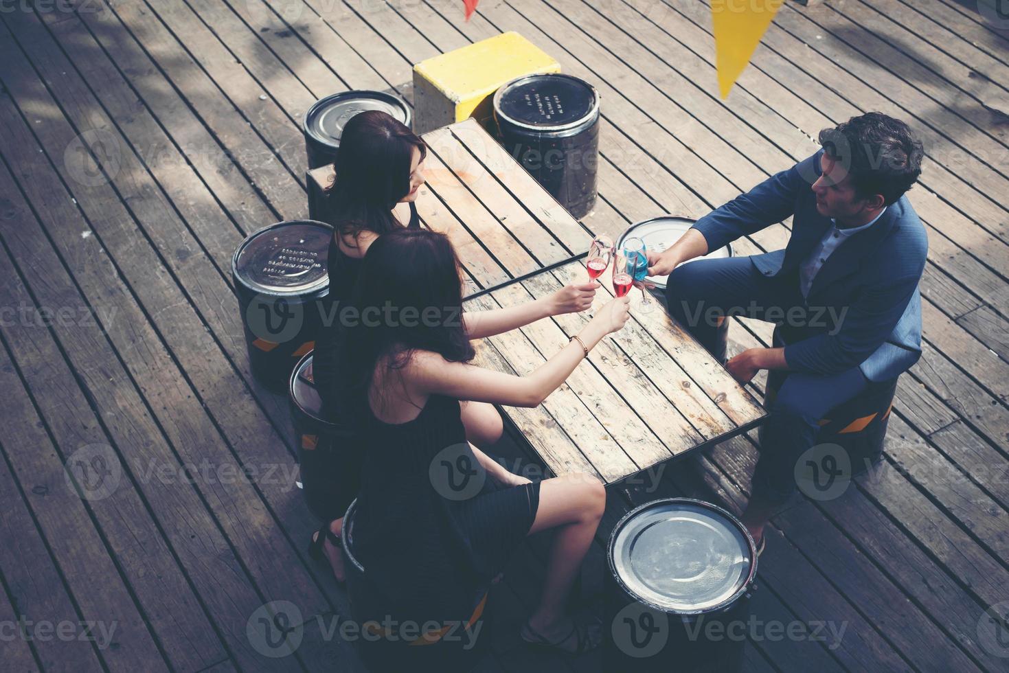 Porträt von glücklichen jungen Freunden, die Spaß haben und zusammen trinken foto