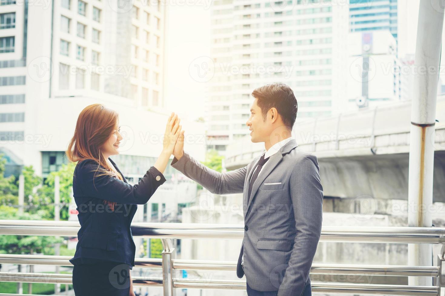 Nahaufnahme von glücklichen Geschäftsleuten, die draußen High Fives geben foto