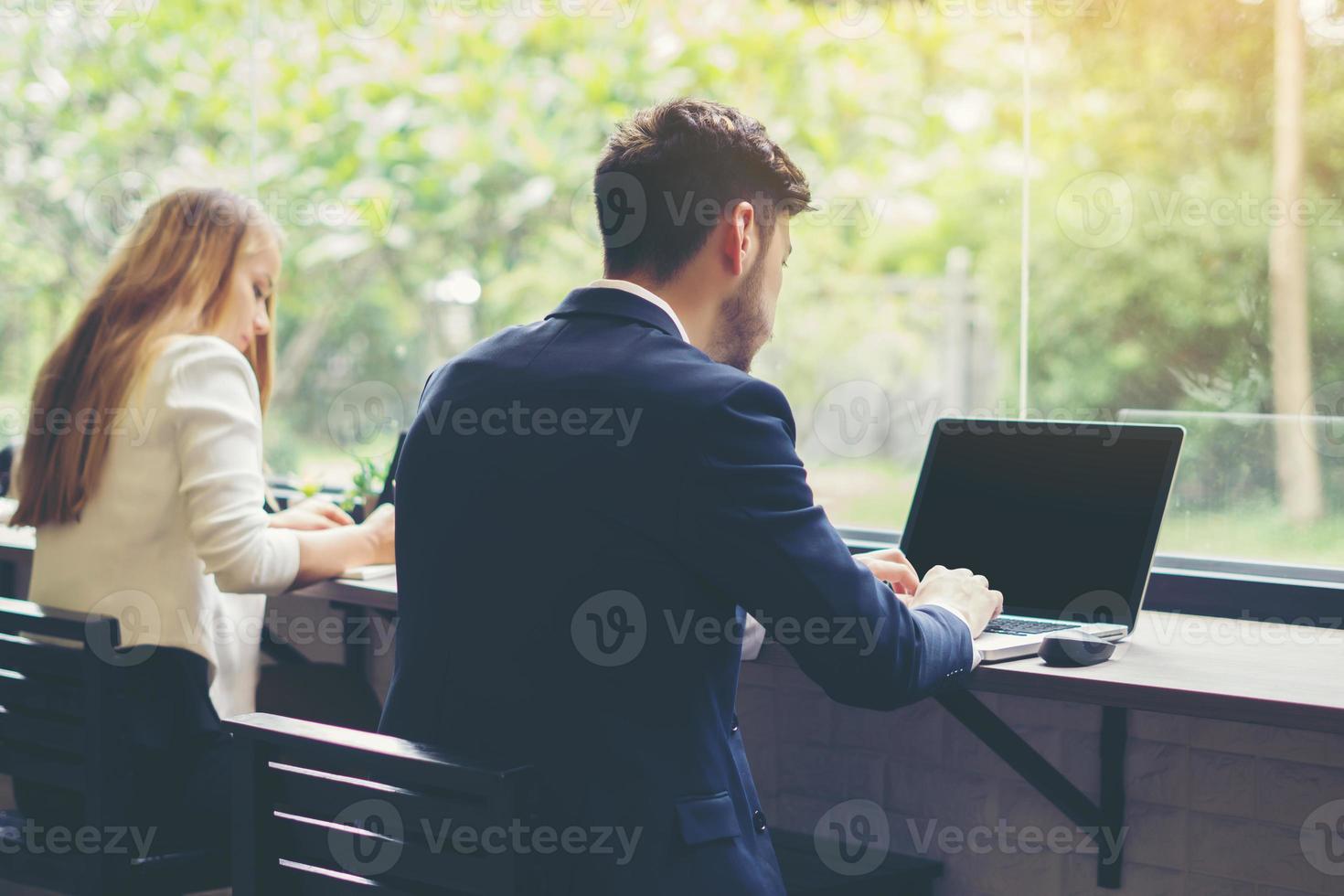 junger Geschäftsmann, der am Laptop im Büro arbeitet foto