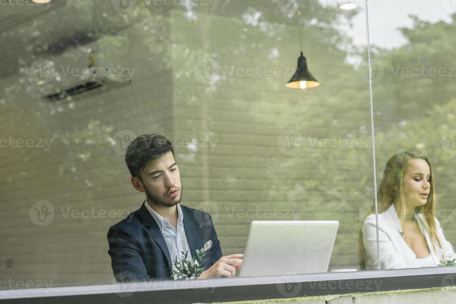 glückliche Kollegen, die gemeinsam im Büro an Laptops arbeiten foto