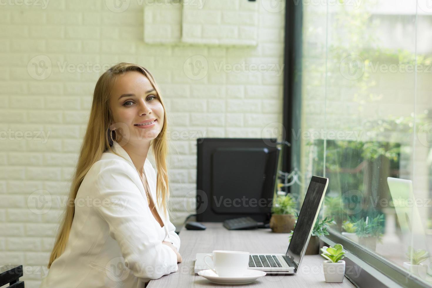 junge Geschäftsfrau, die an ihrem Laptop im Büro arbeitet foto