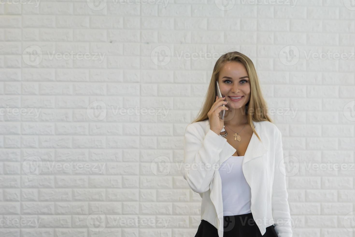 junge Geschäftsdame, die Smartphone während der Arbeit im Büro verwendet foto