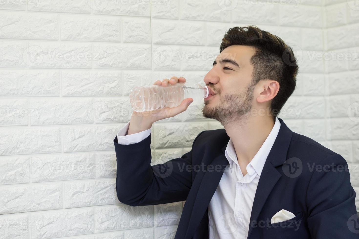 Trinkwasser des jungen Geschäftsmannes im Büro foto