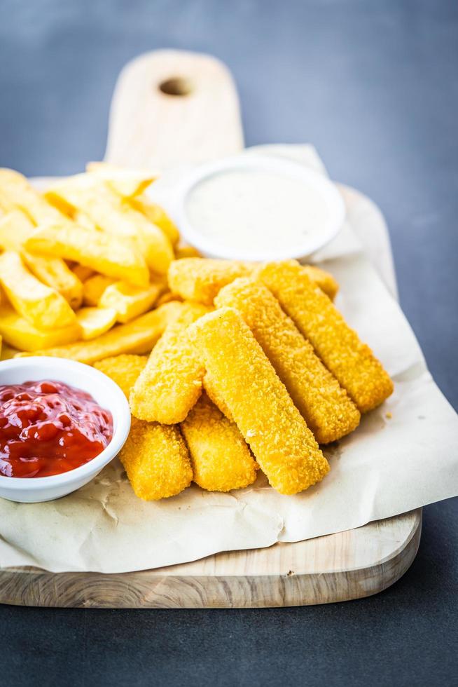 Fischstäbchen und Pommes Frites mit Ketchup und Mayonnaise-Sauce foto