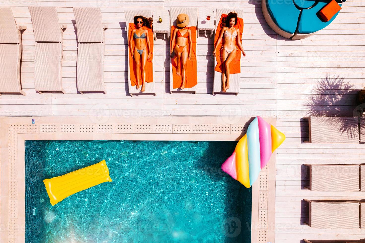 freunde im Badeanzug Wer bräunen im das Sonnenbank im ein Schwimmen Schwimmbad foto