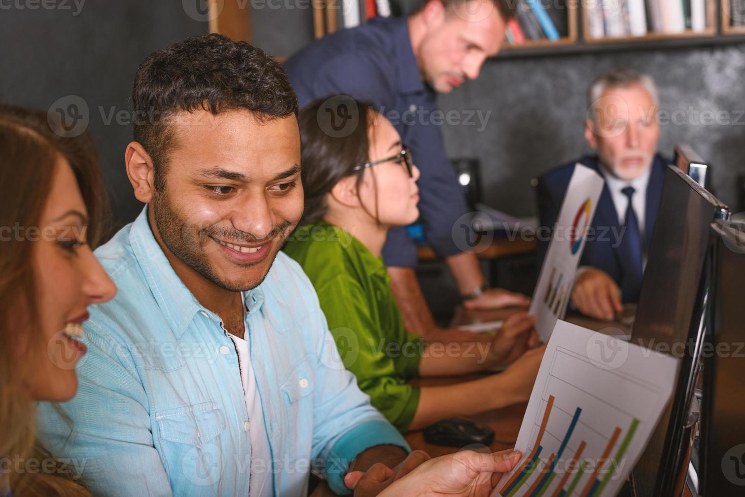 Mannschaft von Menschen Arbeit zusammen im Büro mit Unternehmen Statistiken. Konzept von Zusammenarbeit und Partnerschaft. foto