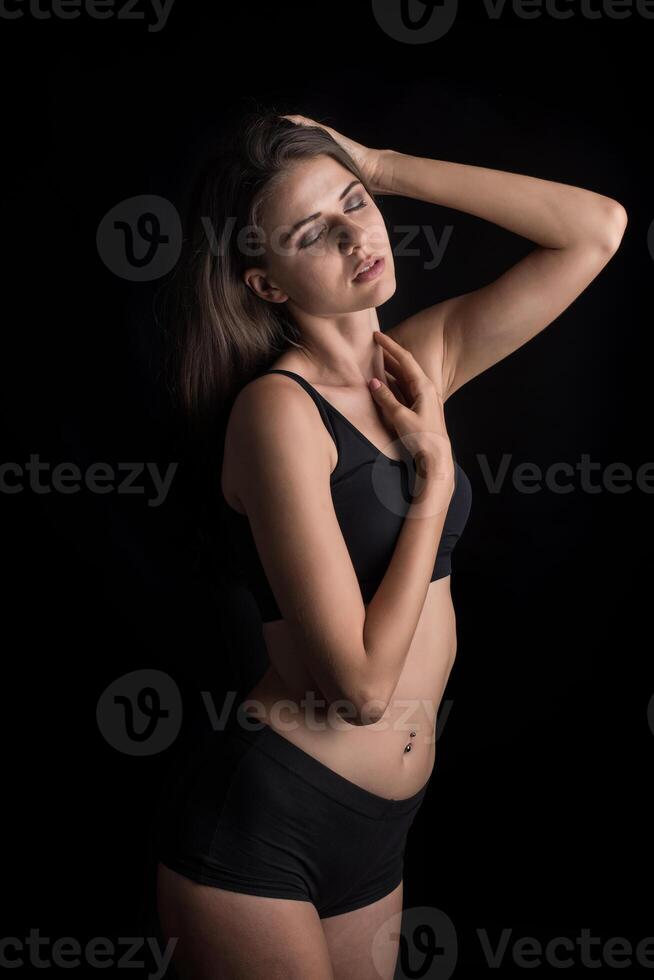 schöne Frau mit gesundem Körper auf schwarzem Hintergrund foto