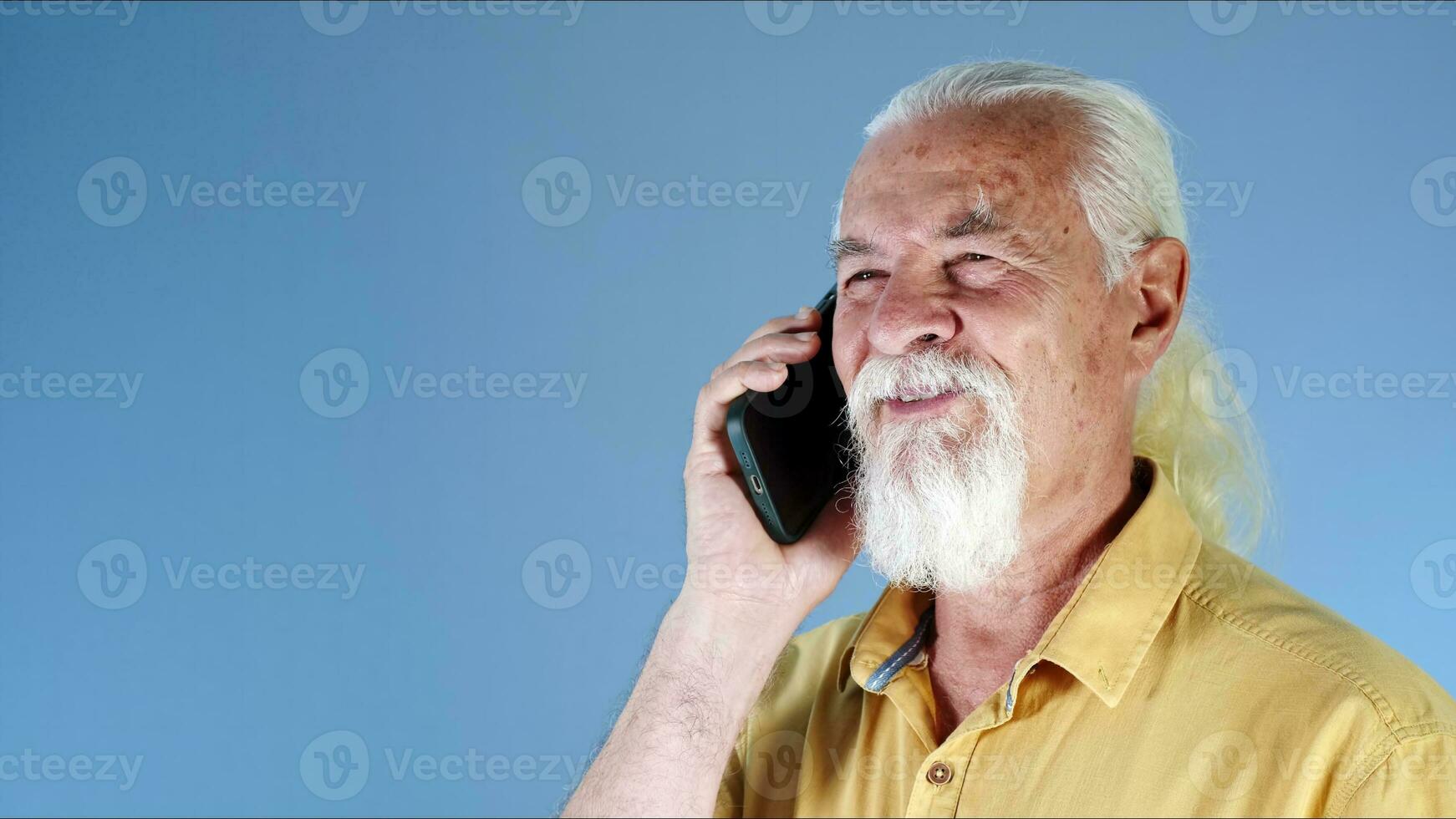 das Weiß behaart alt Mann Gespräche auf das Handy foto