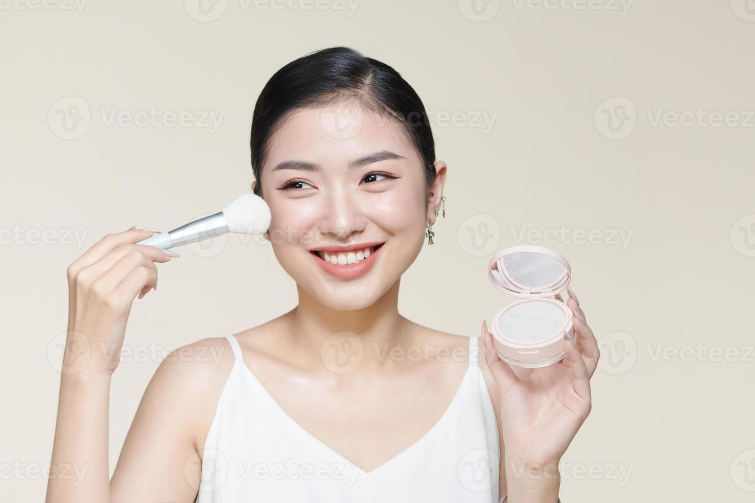 Pulver erröten Frau asiatisch Aussehen Lächeln und bilden Bürste foto