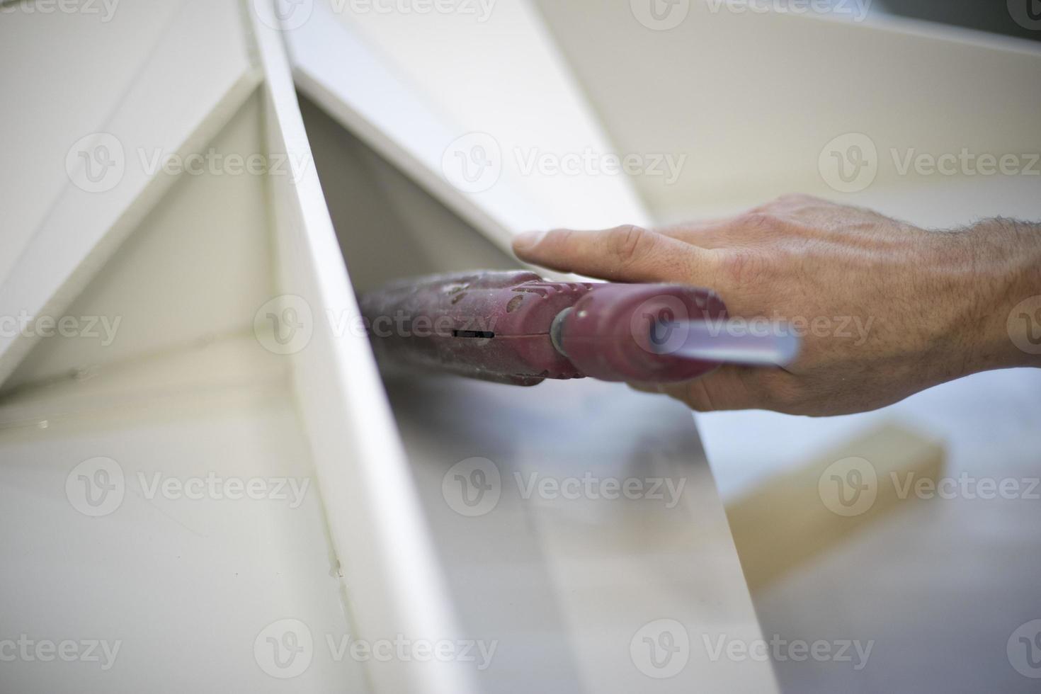 Schaffung von Struktur. Anwendung von kleben zu Oberfläche. Arbeit im Werkstatt. foto