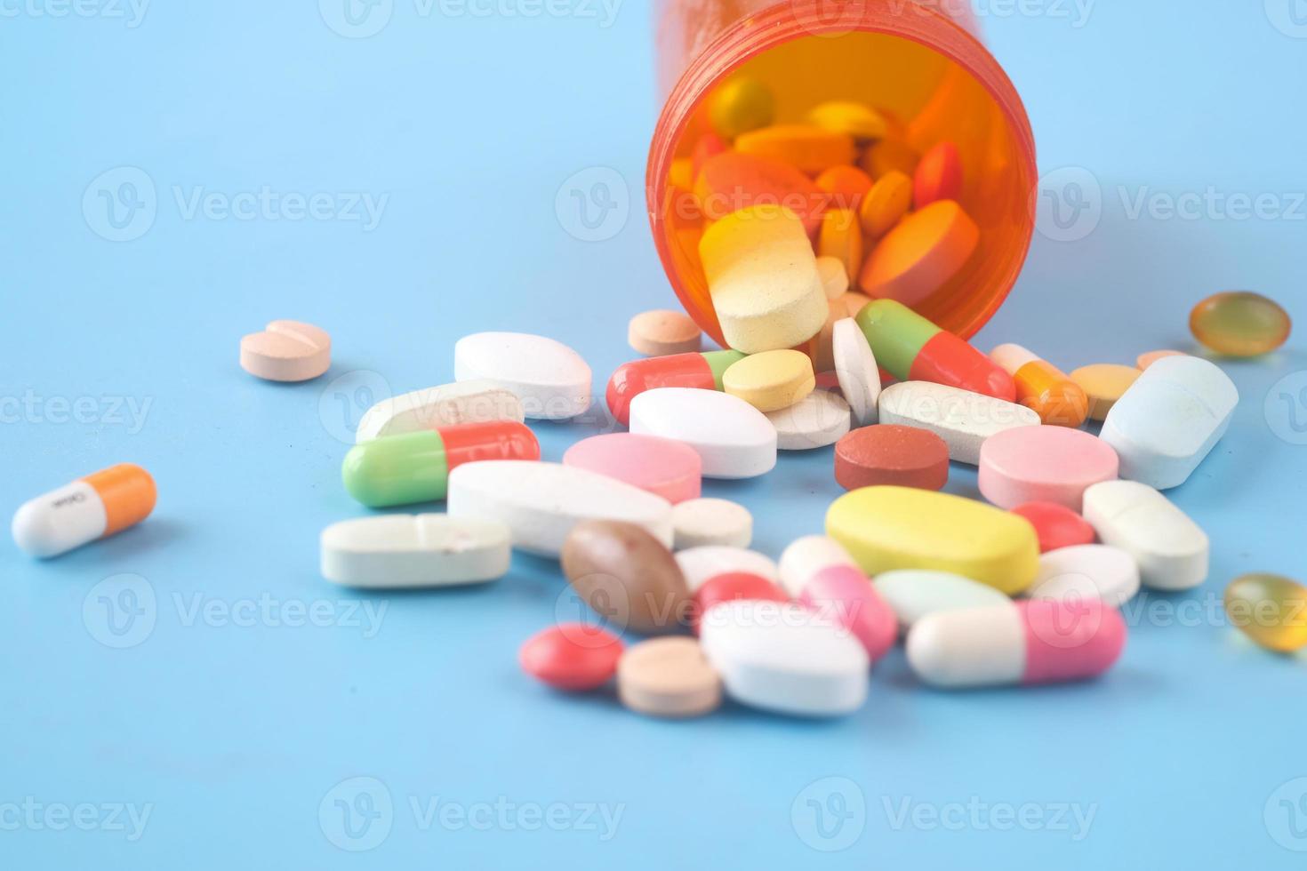 Nahaufnahme von vielen bunten Pillen und Kapseln auf blauem Hintergrund foto