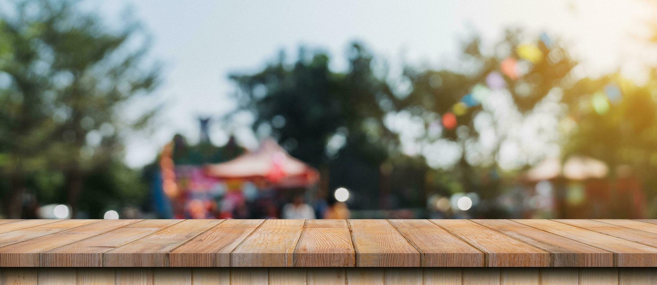 leeren Holz Tabelle und defokussiert Bokeh und verwischen Hintergrund von Garten Bäume im Sonnenlicht, Anzeige Montage zum Produkt. foto