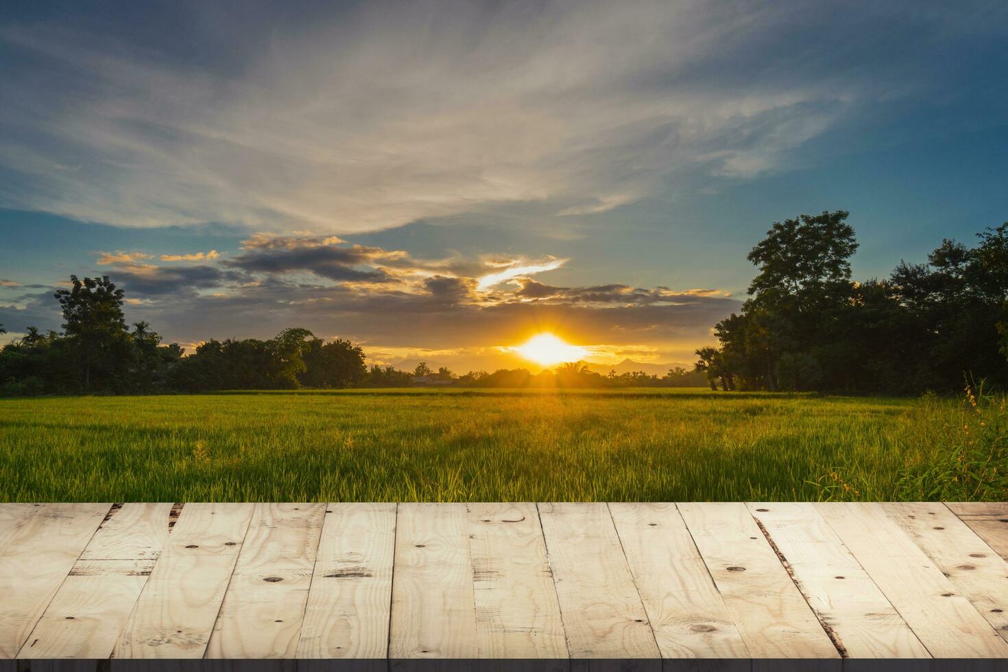 holztisch und reisfeld und sonnenuntergang blauer himmel mit linseneffekt, montage für das produkt. foto