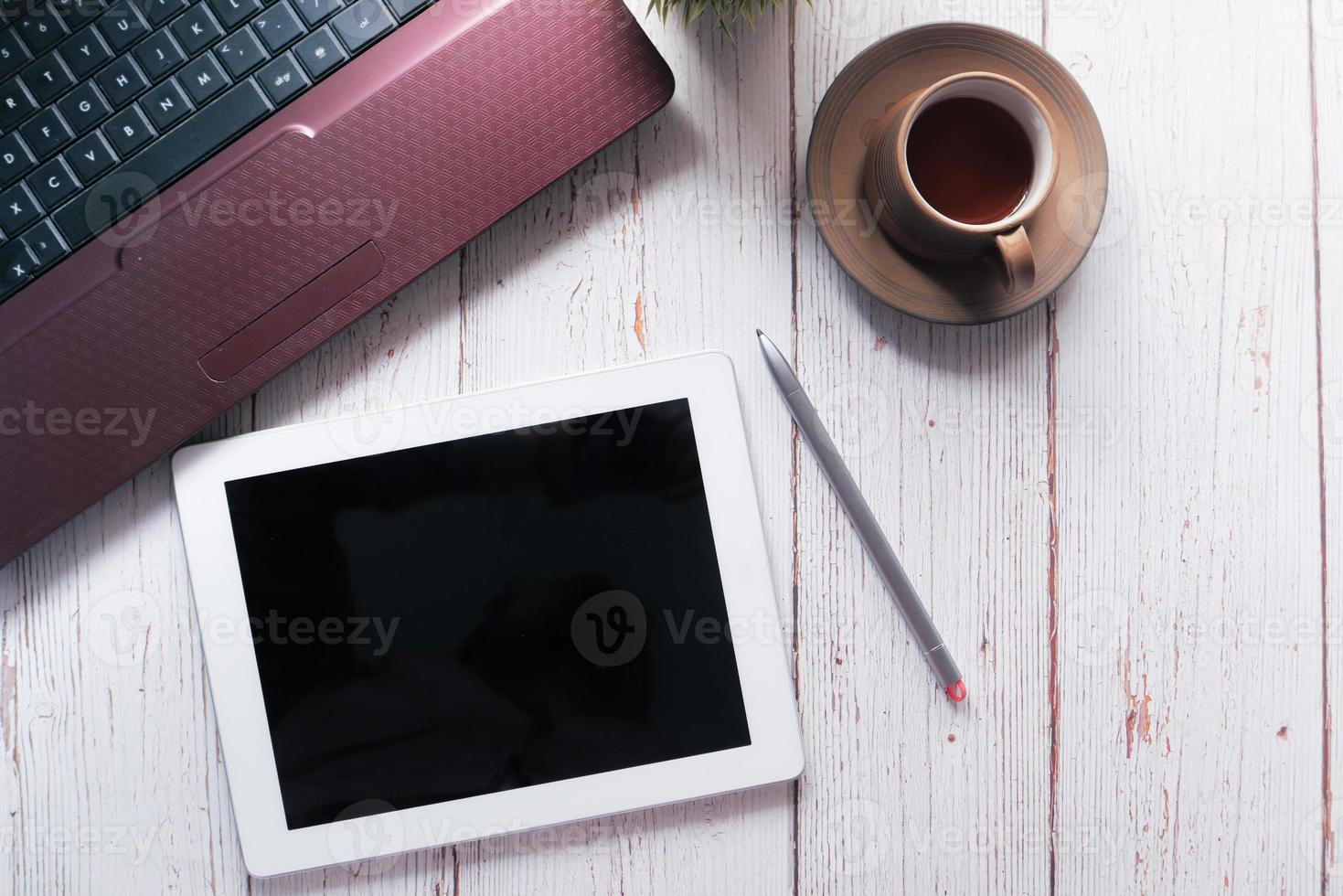 flache Zusammensetzung des digitalen Tablets auf einem Schreibtisch foto