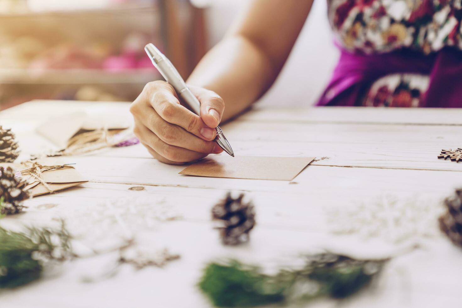 Frau Hand Schreiben schön Weihnachten Karte beim Tabelle foto