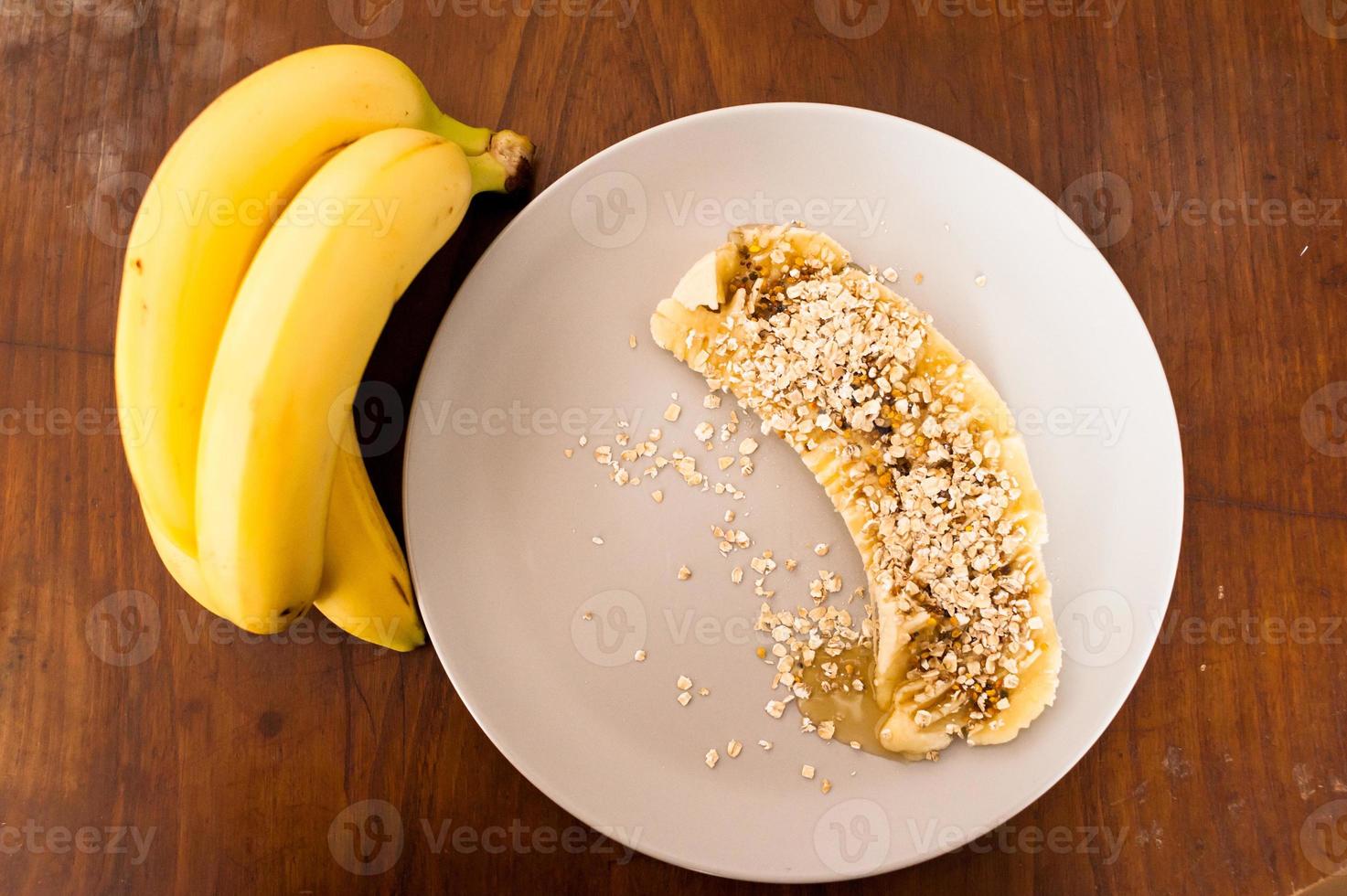 High Angle View einer in Scheiben geschnittenen Banane mit Hafer und Honig bedeckt foto