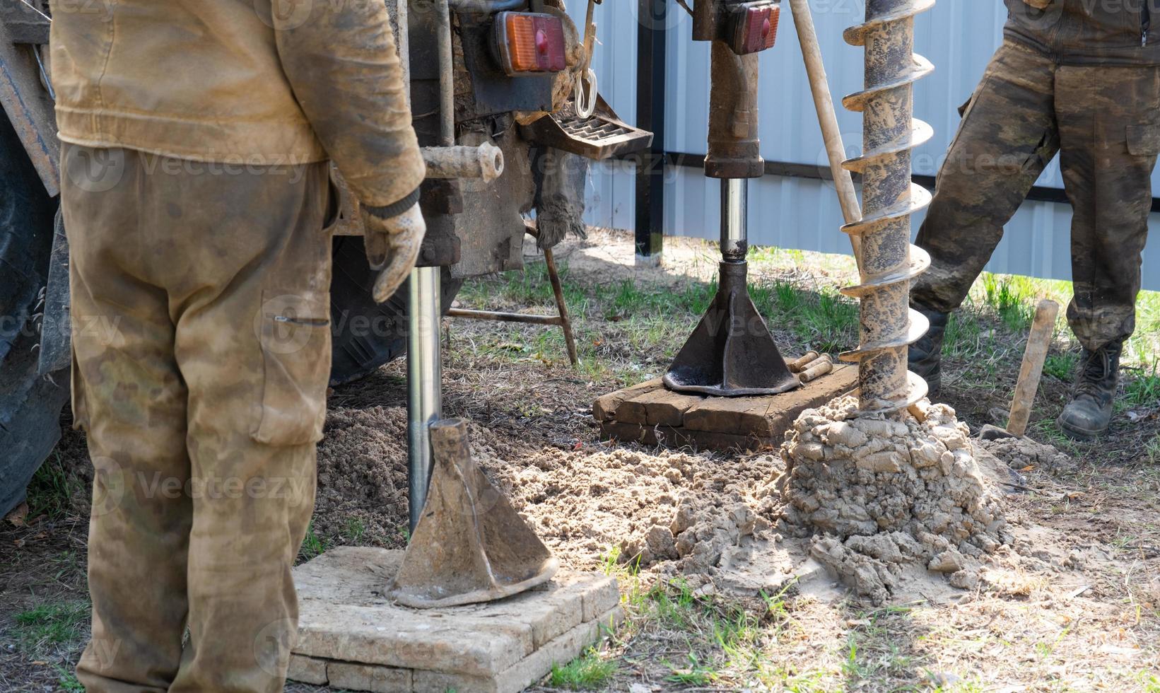 Mannschaft von Arbeitskräfte mit Bohren rig auf Auto sind Bohren artesisch Gut zum Wasser im Boden. Einfügung von Metall Gehäuse Rohr in Boden, Installation von Individuell Trinken liefern, Juni 28, 2022, Russland, foto