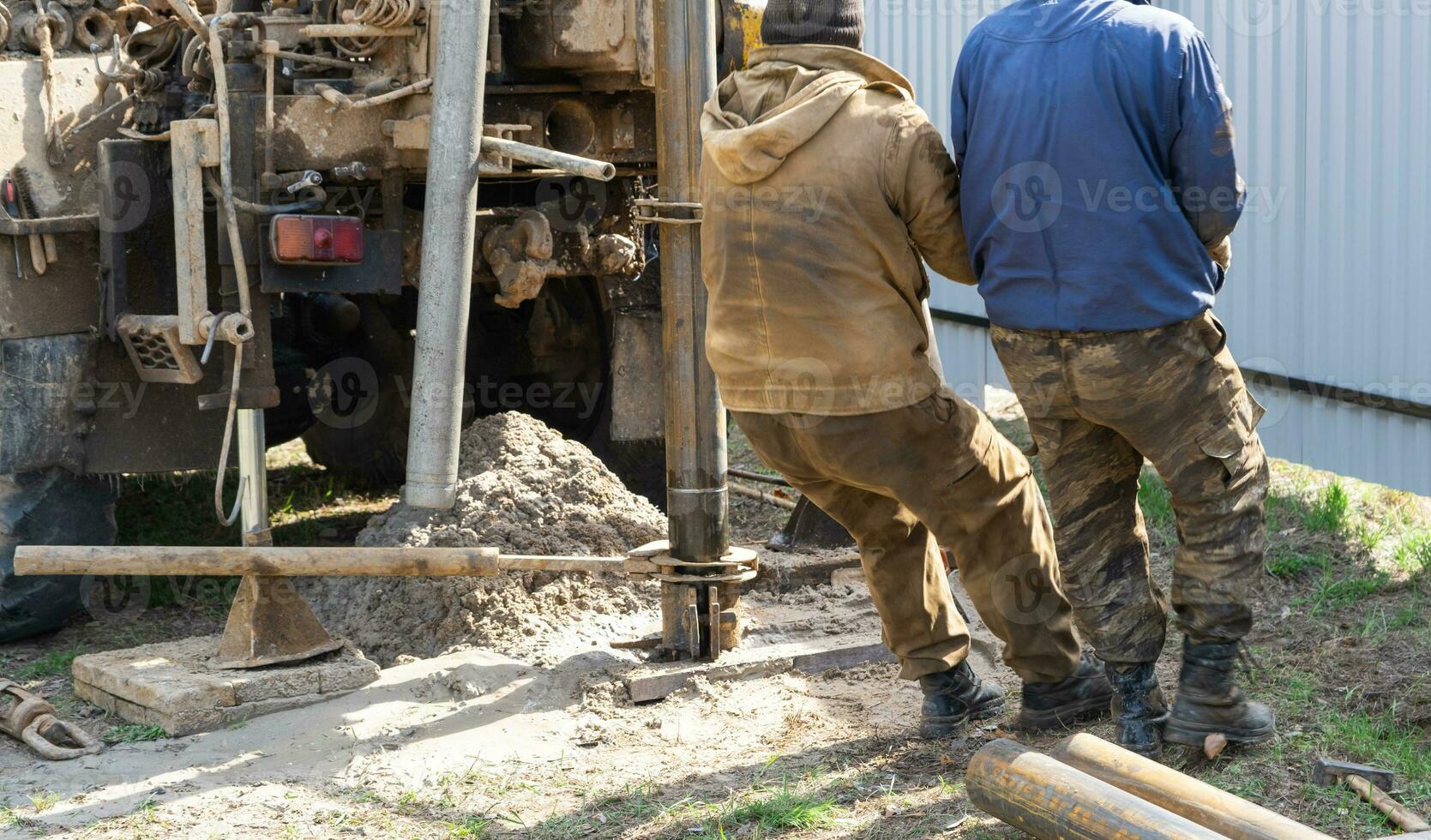 Mannschaft von Arbeitskräfte mit Bohren rig auf Auto sind Bohren artesisch Gut zum Wasser im Boden. Einfügung von Metall Gehäuse Rohr in Boden, Installation von Individuell Trinken liefern, Juni 28, 2022, Russland, foto